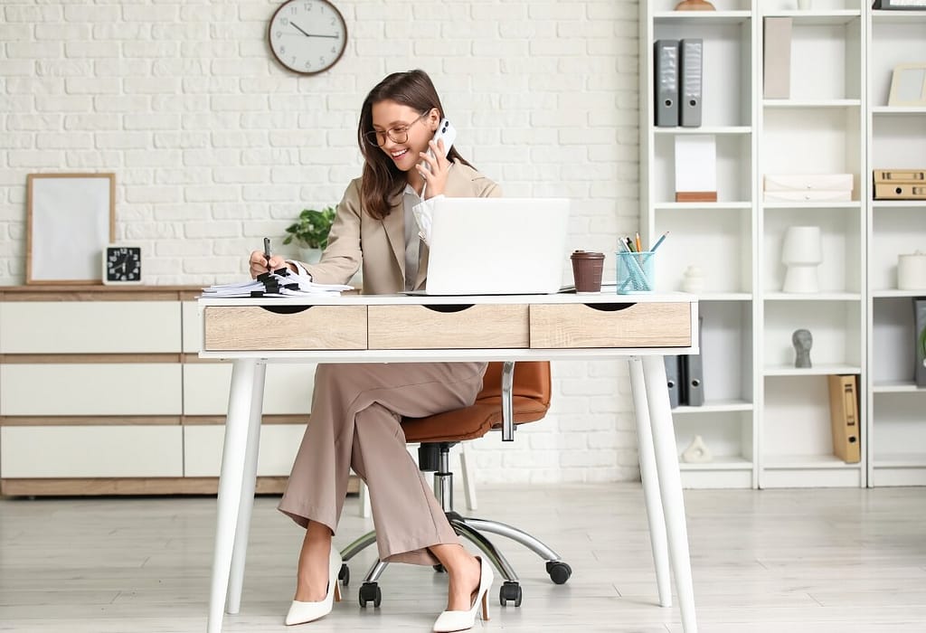 5 Formas de Ganhar dinheiro sem Aparecer Trabalhando Em Casa 3 Mulher elegante focada no notebook em um escritório minimalista, representando como trabalhar em casa com sucesso.