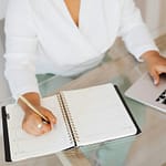 Renda Extra para Introvertidas: 3 Formas Reais de monetizar seu conhecimento sem fazer dancinha no TikTok 4 Mulher elegante e concentrada trabalhando em um notebook em um ambiente minimalista, representando renda extra e produtividade digital.