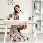 5 Formas de Ganhar dinheiro sem Aparecer Trabalhando Em Casa 4 Mulher elegante focada no notebook em um escritório minimalista, representando como trabalhar em casa com sucesso.